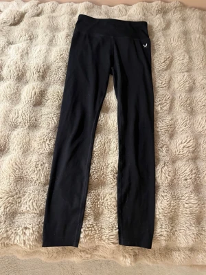 Svarta tights från SOC - Snygga svarta tights från SOC med hög midja och stretchigt material. Perfekta för träning eller chill. Diskret logga på höften och klassisk, tight passform som sitter skönt hela dagen. Orginalpris: 249kr