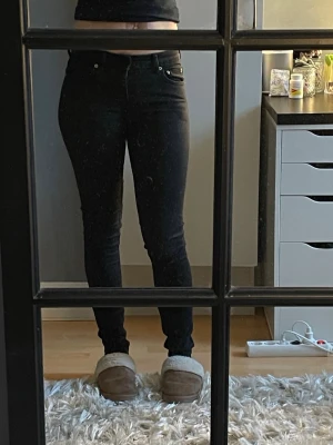Svarta skinny jeans med hög midja - Säljer ett par klassiska svarta skinny jeans med hög midja. Jeansen har smal passform hela vägen ner och stängs med dragkedja och knapp. Perfekta till en enkel topp eller hoodie. Följer kroppen bra, lite tajta för mig men då sitter dom som lågmidjat. Ej använt för flera år. Ej bra pris,,, skriv till mig. (Storlek tror Xs), 129 cm långa