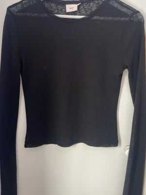 Svart topp från Nelly  - Säljer en svart, tunn och långärmad topp, använt 1 gång så passa på.