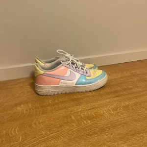 Nike Air Force 1 Pastell Sneakers - Färgglada Nike Air Force 1 sneakers i pastellfärger med paneler i ljusblått, gult, rosa och lila. Klassisk låg modell med vit sula och snörning. Ikonisk Swoosh på sidan och AIR-detalj på sulan. Perfekta för dig som vill sticka ut med din stil. Lite slitna i färgen och använda men fortfarande i fint skick❤️❤️ pris är disskuterbart