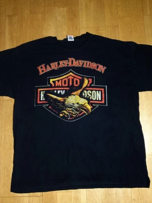 Retro Harley Davidson T-Shirt | XXL / 2XL - T-Shirt med Harley Davidson tryck på framsidan.  Fruit of The Loom - Classic Vaulueweight. XXL / 2XL (Mått finns på bilderna!) 100% bomull.  Se bilder.
