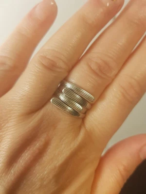 Silver stapelring i modern design - Säljer en cool silvrig ring med staplad look och flera parallella band som ger en unik och modern känsla. Ringen har en blank finish och är tillverkad i 925 sterling silver. Perfekt för dig som gillar stilrena accessoarer med en twist.