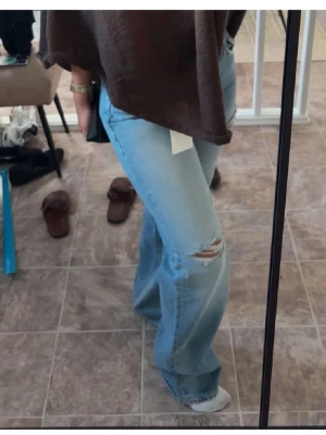 Ljusblå  jeans med slitning - Säljer ett par ljusblåa jeans som tyvärr inte har kommit till användning. Långa på mig så de är klippa symmetriska där nere och passar någon mellan 160-170cm