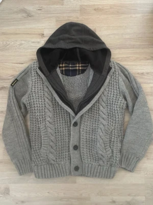 Fodrad stickad cardigan - Otroligt snygg grå fodrad stickad cardigan med mönster. Passar perfekt till kallare väder. Priset kan såklart diskuteras!