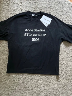 Acne Studios Longsleeve - Svart longsleeve från Acne Studios med vit text 'Acne Studios STOCKHOLM 1996' på bröset. Tröjan är i storlek S och är endast använd ett fåtal gånger. Nypris: 3600kr, mitt pris: 1799kr. Hör av er vid minsta fundering 👍