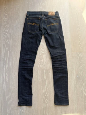 Mörkblåa Nudie jeans - W27 - Säljer ett par riktigt feta Nudie Jeans 👖 Storlek 28/32 | Skick 9/10 | Nästan som nya och perfekta för dig som vill skapa egna fades med tiden 🔥 Passform tight long john Kom gärna med frågor eller prisförslag 💬