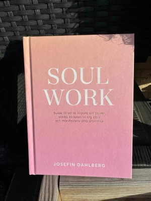 Soul Work av Josefin Dahlberg - Soul Work är en inspirerande bok av Josefin Dahlberg (som har butiken OhLaMoon med kristaller bl.a. ) med hård pärm. Boken guidar dig till att ta tillbaka din power, stärka kärleken till dig själv och manifestera dina drömmar. Perfekt för dig som gillar personlig utveckling och självhjälp. Nyskick! 