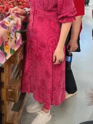 Rosa mönstrad långklänning Pure Female - Snygg rosa långklänning från Pure Female med paisleyinspirerat mönster. Klänningen har v-ringning, långa ärmar med lätt puff och markerad midja. Perfekt för dig som gillar färg och mönster!.Längd 108 cm och 45 cm armhåla till armhåla. Jag är 168 cm.  Kolla in mina övriga klänningar från pure female. Köp fler produkter få rabatt! Djur och rökfritt hem. 