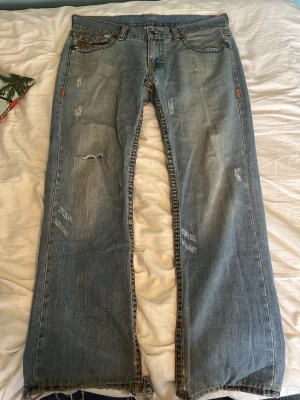 True religion jeans  - Riktigt snygga true religion jeans med cool brodering. De har en riktigt skön oversized/passform och de är nästan lite bootcut. De har större slitage på rumpan men det går att laga! De har även slitage på knäet och i sömmarna längst ner på jeansen. Pris går att diskuteras och skriv för mer bilder!