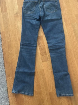 Blå bootcut jeans från Zara - Säljer ett par klassiska blå bootcut jeans från Zara. Jeansen har normal midja, fem fickor och är tillverkade i ett mjukt denimtyg. Perfekta för dig som gillar en retroinspirerad look med utsvängda ben.