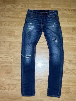 Jackandjones jeans - Säljer dessa feta mörkblå jeans ifrån Jack and Jones. De sitter slim på mig är i stor 29/34. Lagning vid vänstra knät syns inte. Gillar du Grisch stilen är de här perfekta jeansen. Hör av dig om du har några frågor. MVH 