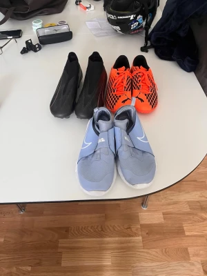 Tre par fotbollsskor Nike & Puma - Säljer tre par gympa skor:: svarta puma fotbollsskor storlek 39::oranga puma inne fotbollsskor storlek 39:: ljus blåa Nike inne gympa skor storlek 38,5 dom e perfekta för dig som vill ha snygga skor 