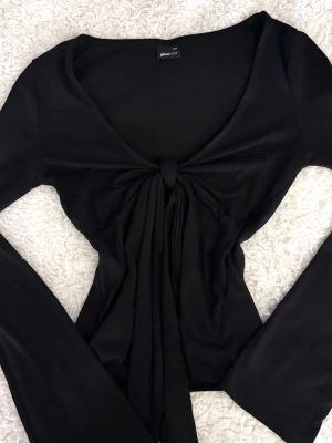 Svart Topp Med Knyt Fram - Snygg och enkel topp i svart med en fin knytdetalj fram som gör den lite extra ✨ Perfekt till både vardag och kväll. Använd få gånger och i fint skick🎀Pris kan diskuteras 