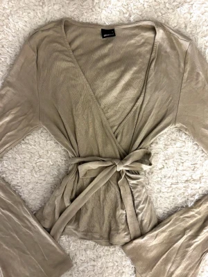 Beige Knyttröja - Mjuk och bekväm beige tröja med knytning, perfekt för yoga, träning eller en avslappnad vardagslook ✨ Lätt och skön att bära med bra passform. Använd få gånger och i fint skick🧘🏻‍♀️Pris kan diskuteras 