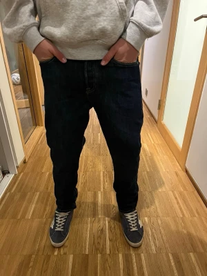Mörkblå raka jeans - Snygga mörkblå jeans med rak passform och klassiska fickor fram och bak. Jeansen har kontrastsömmar och är tillverkade i denim, vilket ger en tidlös look. Perfekta för en avslappnad stil och passar till det mesta.