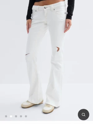 Vita bootcut jeans med slitningar - Vita jeans från Gina tricot som är slutsålda,använda 1 gång dem är även i tall som referens är jag ca 165 och dem är rätt så långa på mig men det går att sy upp eller sprätta upp💕 