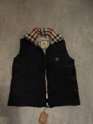 Burberry väst  - Helt ny och oandvänd burberry väst storlek XL. Taggen sitter fortfarande kvar men den är inte rikti 