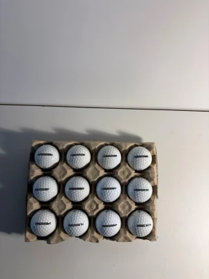 Callaway supersoft  - Säljer ett set med 12 vita supersoft golfbollar som är i väldigt bra skick. Bollarna har klassiskt dimple-mönster och svart text på sidan. Perfekt för dig som vill fylla på golfväskan inför säsongen.