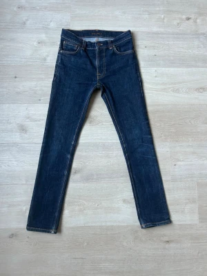 Blåa Nudie Thin Finn Jeans Storlek W30 L30 - Fina Nudie Jeans i blå färg. Jeansen är i mycket bra skick och sparsamt använda. |  Äkta som allt annat jag säljer! ✅ |  Storlek: W30 L30 | Skick: Mycket Bra Skick | Färg: Blå | Märke: Nudie | Modell: Jeans |   Hör gärna av dig vid frågor så svarar jag så fort jag kan! 😁 |  (SKU - 126)