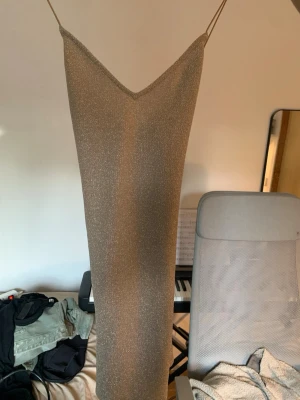 Glittrig klänning med öppen rygg - Köpte denna på H&M för några år sedan men har aldrig fått ett tillfälle att använda den. Den är i storlek S. 💕💕 Skriv om ni vill ha fler bilder ☺️