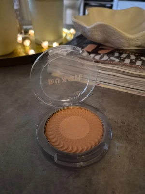 Buxom bronzer i varm ton - Säljer en bronzer från Buxom i en varm, gyllenbrun nyans. Kommer i en rund plastförpackning med transparent lock och snyggt mönstrad yta på pudret. Perfekt för att ge ansiktet en solkysst look och framhäva dina drag. Färg Backyard bronze . Testad. Finns ett litet jack i produkten . En fin bronzer.
