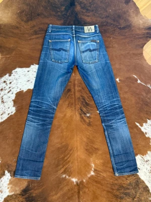 Nudie GrimTim DryComfortSelvage - Tjena! Säljer dessa Nudie GrimTim i Modellen DryComfortSelvage med helt perfekta fades, byxorna är helt utan lagningar vilket är ett under med denna washen, W31/L36 men passar bättre som L34, hör av dig vid funderingar!🙌