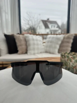 Svarta solglasögon / aktivitetsglasögon  - Helt nya, sportiga solglasögon med svart båge och mörka linser. Uv-skydd och passar både dam och herr, onesize. Passar bra till både löpning och skidåkning. 