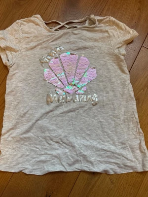 Grå T-shirt med rosa/silver snäcka - Grå T-shirt med rosa/silver paljett snäcka i barnstorlek 164