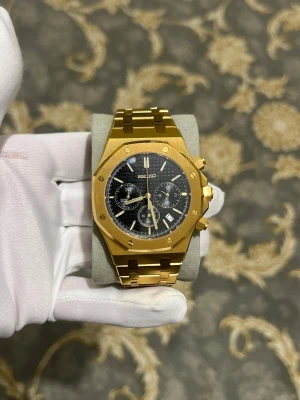 Seiko mod royal oak  - Stilren guldfärgad Seiko klocka med svart urtavla och kronograffunktion. Klockan har en robust länkarmband i metall och markerade index. Urtavlan har flera små visare och datumvisning. Perfekt accessoar för dig som gillar en lyxig och modern look.