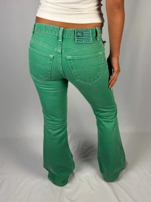Supersnygga Ralph Lauren jeans - Supersnygga gröna bootcut Ralph Lauren jeans | Storlek 28 | Jättefint skick överlag men finns lite färgstänk på bakfickorna (bild 4). Bara coolt och unikt enligt mig! | Jag är 168cm lång och väger 60kg | Mått: Ytterbenslängd: 101cm. Midjebredd: 40cm. Lårbredd: 28cm. Fotöppning: 25cm. Kontakta mig vid fler frågor eller funderingar!💕