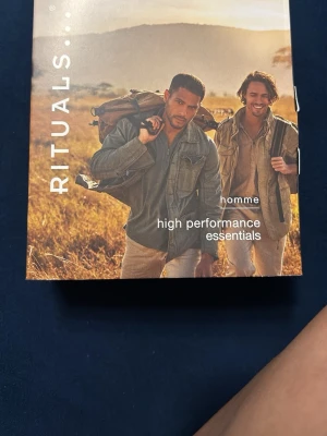 Rituals Homme High Performance Kit - Säljer ett Rituals Homme High Performance Essentials kit. Innehåller bland annat en 24h hydrating face cream i gel-formula, perfekt för återfuktning av ansiktet. Förpackningen är stilren i bruna och svarta toner. Perfekt present till någon som gillar hudvård.
