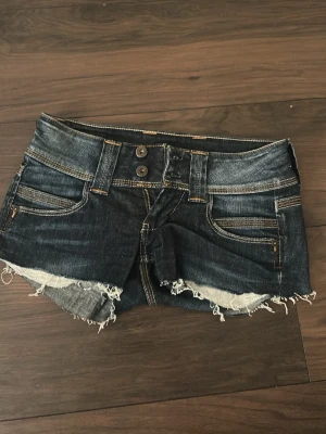 Lågmidjade Jeansshorts pepe - Säljer ett par jätte snygga mörkblå jeansshorts från pepe, det var jeans först som jag klippte till shorts, är väldigt korta men jätte snygga💞