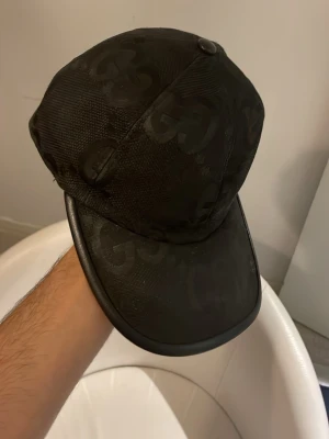Keps - En svart keps med monogram över hela som är perfekt nu inför sommaren och soliga dagar! | Storlek; s (57cm) | Inget og medföljer! Pris kan diskuteras vid en snabb o smidig affär! Byten är väldigt intressanta! /Mvh Nitro🫆