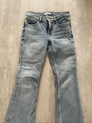 Ljusblå bootcut jeans från Perfect Jeans - Säljer ett par ljusblå bootcut jeans från Perfect Jeans. Klassisk femficksmodell med normalhög midja och utsvängda ben. Jeansen har bälteshällor och stängs med dragkedja och knapp. Perfekta för en avslappnad och trendig look.