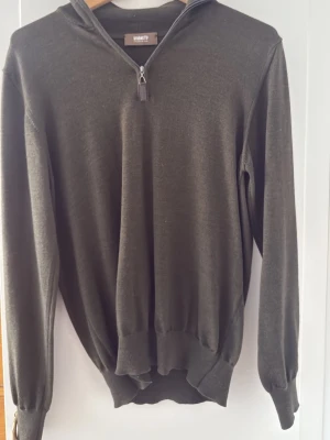 Ströms half zip - Mörkgrön långärmad tröja från Ströms man med halv dragkedja framtill. Tröjan har ribbade muddar vid ärmslut och nederkant, samt en avslappnad passform. Riktigt schysst merinoull och nyskick