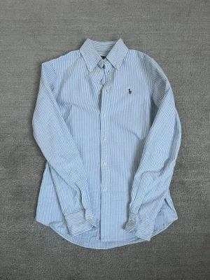 Ralph Lauren Skjorta  - Säljer nu denna snygga Ralph Lauren skjorta! Storleken är i XS och har en snygg passform. Nypris på skjortan är 1299 kr. Skjortan är i mycket bra skick, utan fläckar. Om du har några frågor eller funderingar är det bara att fråga!🤗