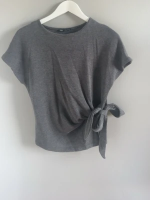 Snygg t-shirt med knyte  - Jätte snygg t-shirt med knyte från Zara. Säljs för jag måste rensa bort kläder. Inga defekter 