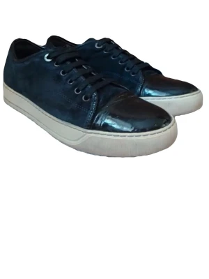 Svarta Lanvins - Snygga svarta sneakers med mattsvart mocka och glansiga lackdetaljer på tån. Skorna har svarta snören och vit sula som ger en clean kontrast. Perfekta för dig som vill ha en stilren men ändå unik look.