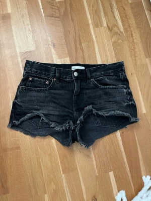 Svarta jeansshorts med fransig kant - Säljer ett par svarta jeansshorts från Perfect Jeans. De har rå, fransig kant nertill och klassisk femficksdesign. Är i storlek 34 men skulle säga att de upplevs som en 34-36