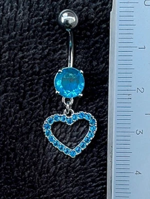 NY oanvänd Navelpiercing med hänge | Kirurgiskt stål | Hjärta och blåa stenar  - 💕30% Bundle-rabatt vid köp av minst 2 artiklar. ⭐️NY oanvänd piercing i kirurgiskt stål; rostfritt och säkert för läkta piercingar.                               📏MÅTT ⭕️Stavens längd: 10mm ⭕️Stavens tjocklek: 1,6mm ⭕️Smyckets totala längd: 35mm                                                                         🤍Färger: Silver och blå                                                         💌Skickas spårbart via Plick SafePay.