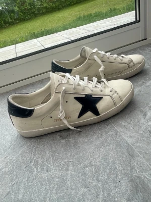 Golden goose  - Riktigt fräsha och snygga vita golden goose skor. Säljes till ett bra pris. Perfekt nu till sommaren. Box med tillbehör medföljer. Lätt slitage, inga hål. Mycket bra skick. Storlek 44. Skickar snabbt!  