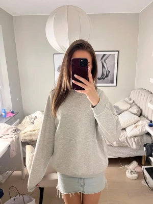 Ljusgrå basic sweatshirt - En enkel och stilren ljusgrå sweatshirt i mjukt bomullsmaterial. Tröjan har rund halsringning, långa ärmar och ribbade muddar vid ärmslut och nederkant. Perfekt för en avslappnad och clean look. Stor I storleken, jag är 169. 🩶