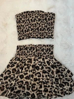 Leopardmönstrat tvådelat set - Säljer ett två delat sätt från shein. Toppen är bandeau-modell med smock och kjolen har hög midja, smock och volanger. Materialet är lätt och stretchigt. Aldrig använd endast testad 
