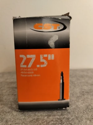 CST slang 27.5 tum racerventil - Cykelslang från CST för 27.5 tum hjul, passar däckbredd 1.90/2.125. Utrustad med racerventil på 48 mm. Förpackningen är orange och svart med tydlig märkning. Perfekt för dig som behöver en ny slang till din cykel.