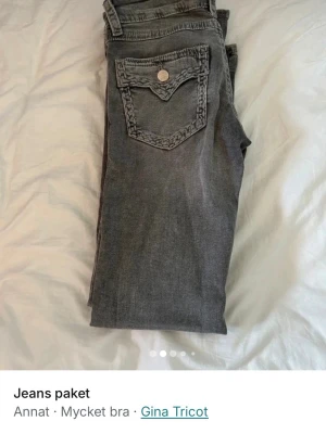 Grå jeans från Gina Tricot - Snygga utsvängda och lågmidjade grå jeans från Gina Tricot i storlek 152 med dekorativ bakficka och markerade sömmar. Jeansen har en klassisk femficksmodell och är tillverkade i denim med en cool tvättad look. Perfekta för dig som gillar en avslappnad men trendig stil.                                 Innerbenslängden:77cm