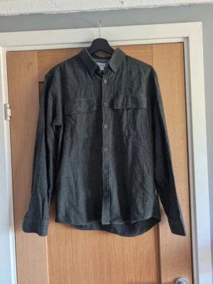 Overshirt Lindbergh - Snygg grå skjorta från Lindbergh i relaxed fit. Skjortan har två bröstfickor med knappar och klassisk krage. Perfekt för dig som gillar en enkel men stilren look.