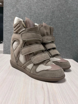 Isabel marant skor - Snygga beige wedge sneakers med högt skaft och tre breda kardborreband. Skorna har en mix av mocka och textil samt detaljer i ljusrosa skinn. Perfekta för dig som vill ha en cool och trendig look med extra höjd.