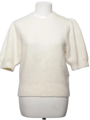Vit stickad tröja med puffärm - Säljer en vit stickad tröja med korta puffärmar och rund halsringning. Tröjan har en mjuk och fluffig känsla, perfekt för att skapa en stilren och trendig look. Passar till både jeans och kjol för en snygg outfit.
