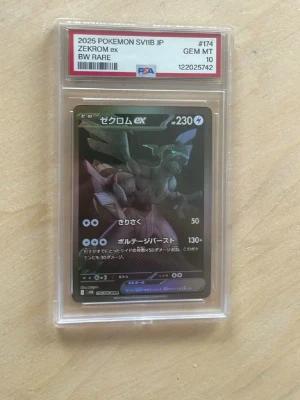 Zekrom ex Pokémonkort PSA 10 - Japanskt Zekrom ex Pokémonkort från 2025 SV11B, BW Rare, graderat PSA 10 GEM MT. Kortet har en mörk design med Zekrom i fokus och är innesluten i ett genomskinligt plastskydd. Perfekt för samlare av Pokémonkort.