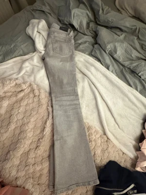 Snygga gråa bootcut jeans  - Snygga ljus gråa bootcut jeans med vita sömmar från Gina Tricot i storlek 32 